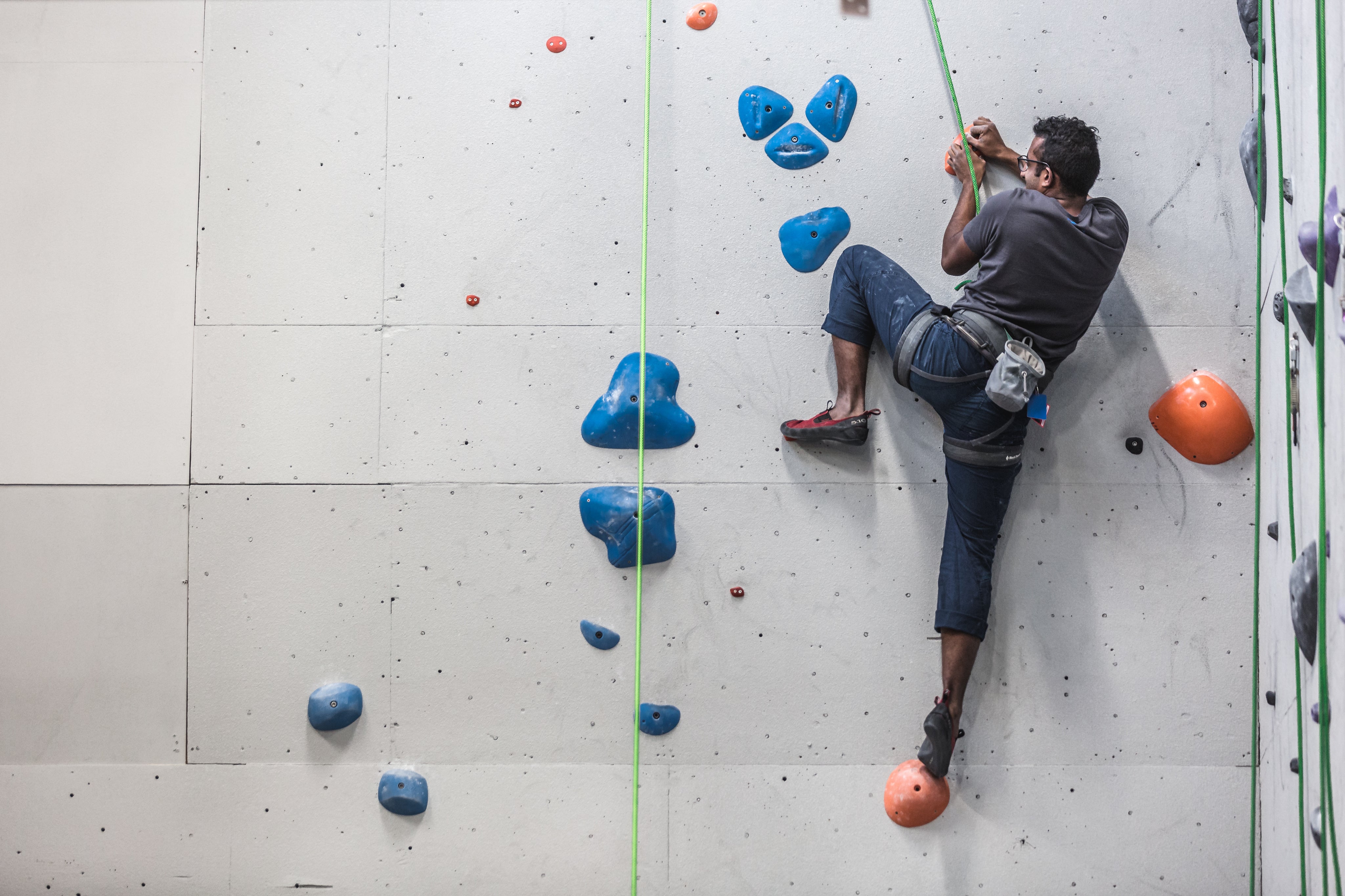 files/a-man-scales-the-side-of-a-rock-climbing-wall.jpg